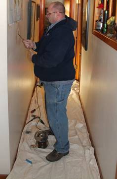 Fenix HVAC tech doing work in a home's hallway with a drop cloth below him