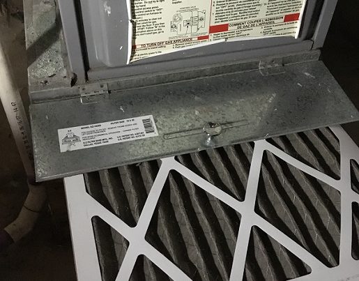 Dirty air filter being pulled out of a furnace that is not blowing hot air